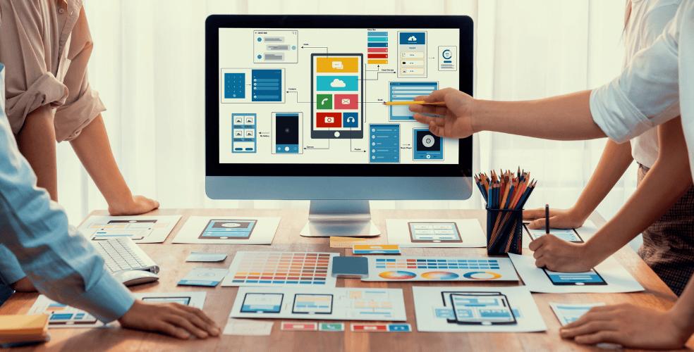 Team di design che lavora su wireframes e mockups per un'interfaccia utente facile da usare, con enfasi su usabilità e esperienza utente.