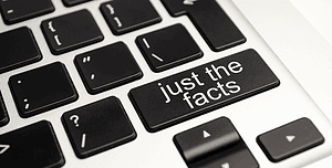 Tasto 'just the facts' su una tastiera di computer, simbolizzando la necessità di affidabilità e verità nell'etica del web design.